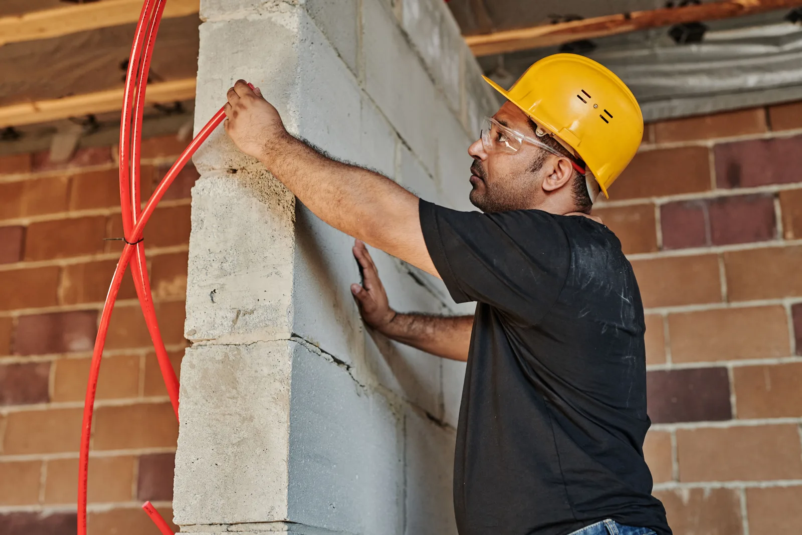 Construction worker with hard hat installing electrical cables on a site. Room for another electrical contractor: market and startup basics