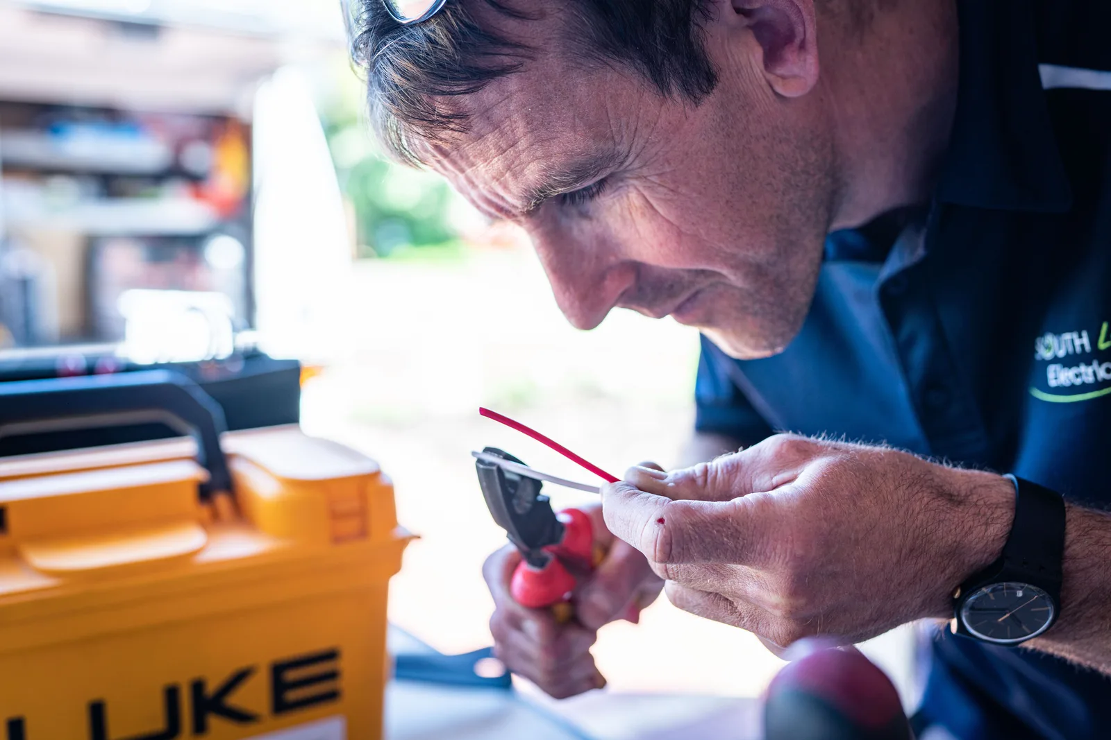 Focused technician working on wiring with tools in a workshop setting. Why do some electrical contractor price lists lose money on every job?